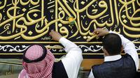 Pekerja menyulam kaligrafi Islam pada Kiswah Kabah menggunakan benang perak murni dan benang perak berlapis emas di pabrik Kiswah di Mekah, Arab Saudi, Rabu (14/7/2021). Kiswah yang menutupi Kabah diganti setiap tahun untuk umrah atau haji. (AP Photo/Amr Nabil)