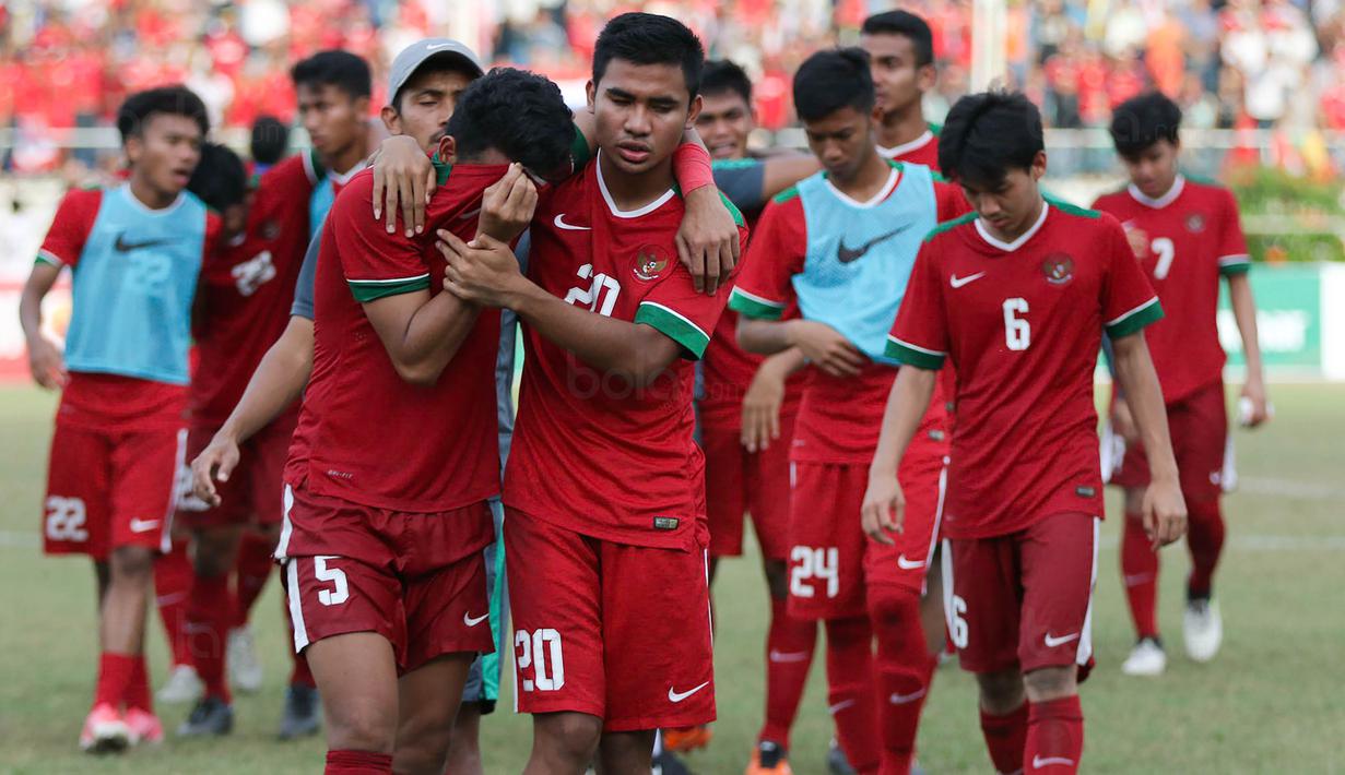 Bek Timnas indonesia U-19, Nurhidayat Haji Haris, ditenangkan Asnawi Mangkualam usai kalah dari Thailand U-19 pada laga Piala AFF U-18 di Stadion Thuwunna, Yangon, Jumat (15/9/2017). Indonesia kalah adu penalti dari Thailand. (Bola.com/Yoppy Renato)