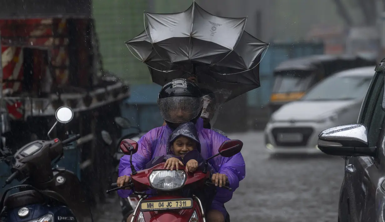 Pengendara melewati hujan di Mumbai, India, Minggu, 2 Juli 2023. Musim hujan India berlangsung Juni hingga September. (AP Photo/Rafiq Maqbool)