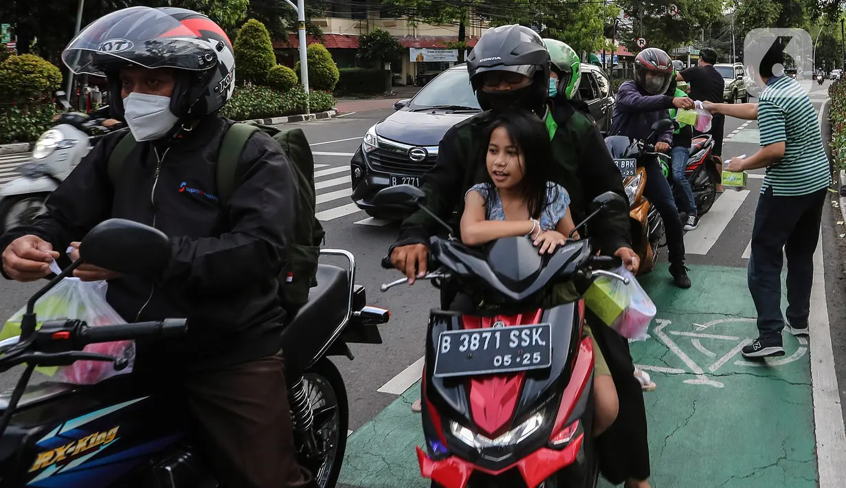 Jemaat membagikan takjil kepada masyarakat menjelang buka puasa di Gereja GPIB Effatha, Jakarta, Rabu (20/4/2022). Momen menjelang buka puasa Ramadhan digunakan jemaat GPIB Effatha berbagi takjil gratis untuk kaum Muslimin di Jalan Melawai, tepatnya di depan gereja itu. (Liputan6.com/Johan Tallo)