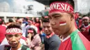 Suporter Garuda Muda mengecat pipinya dengan gambar bendera Merah Putih untuk mendukung Timnas Indonesia U-22 pada laga melawan Timor Leste, Minggu (20/8). Indonesia melakoni laga ketiga dalam lanjutan grup B SEA Games 2017. (Liputan6.com/Faizal Fanani)