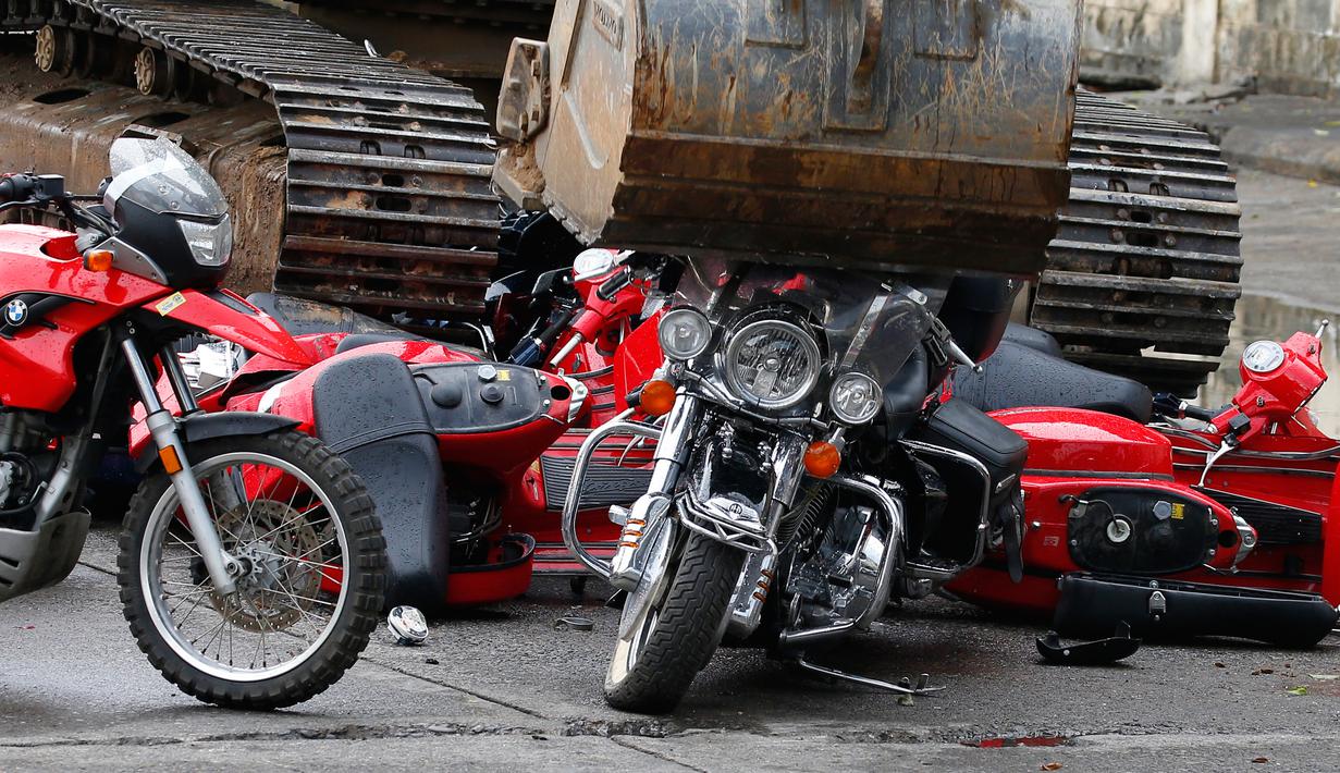 Sejumlah motor hasil selendupan dilindas ekskavator untuk dihancurkan di kantor Biro Bea Cukai di Manila, Filipina (30/5). Penghancuran kendaraan hasil selundupan ini juga disaksikan Presiden Rodrigo Duterte. (AP/Bullit Marquez)