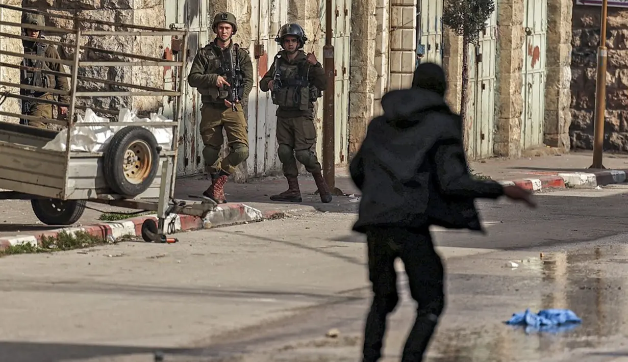 Seorang pengunjuk rasa Palestina menghadapi tentara Israel saat bentrokan di pusat Kota Hebron, Tepi Barat, 4 Maret 2022. (HAZEM BADER/AFP)