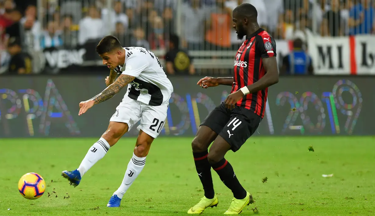 Pemain Juventus, Joao Cancelo menembak bola melewati pemain AC Milan, Tiemoue Bakayoko pada laga Piala Super Italia 2018, di Stadion King Abdullah Sports City, Kamis (17/1). Juventus keluar sebagai kampiun dengan meraih kemenangan tipis 1-0. (AP Photo)