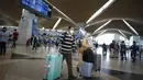 Pelancong berjalan untuk check-in di Bandara Internasional Kuala Lumpur, Sepang, Malaysia, Jumat (1/4/2022). Mulai hari ini, Malaysia membuka perbatasannya untuk orang asing dan pelancong yang sudah divaksin COVID-19 lengkap tanpa harus menjalani karantina. (AP Photo/Vincent Thian)