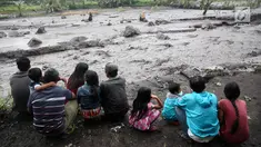 Warga mengamati aliran lahar dingin yang melintasi Sungai Yeh Sah di Karangasem, Bali, Sabtu (2/12). Banjir lahar dingin dari Gunung Agung tersebut mengundang perhatian warga sekitar. (Liputan6.com/Immanuel Antonius)