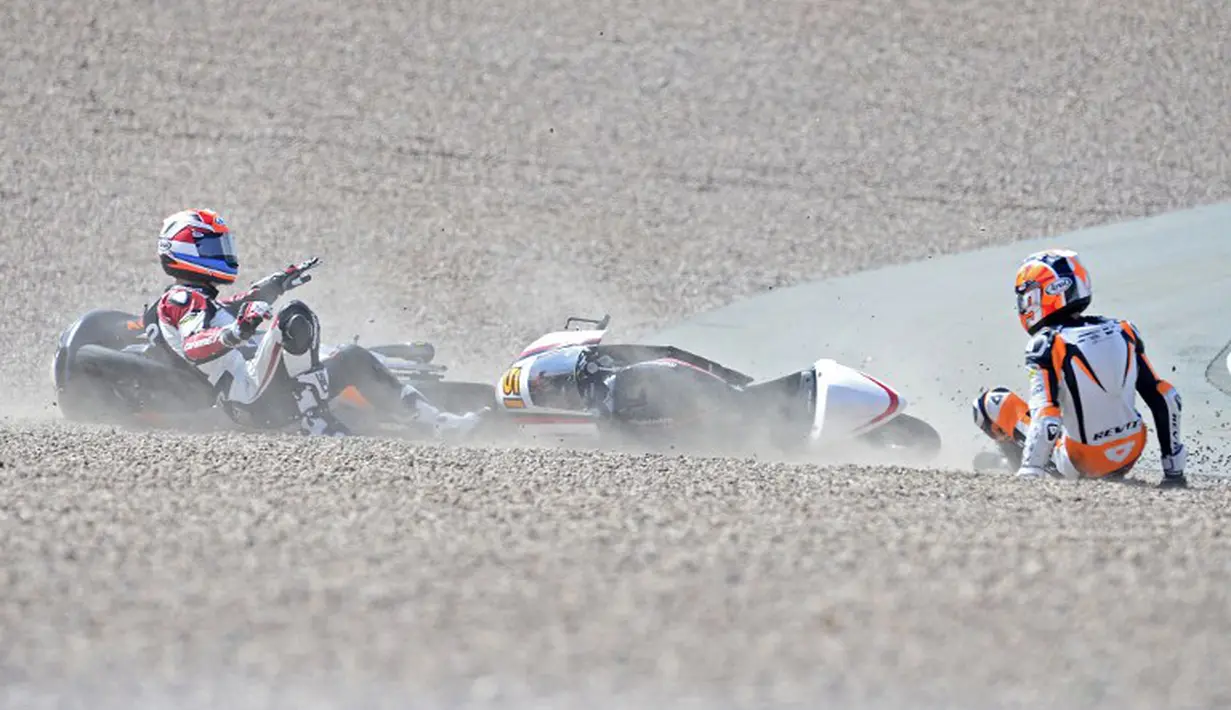 Pembalap asal Belanda, Bryan Schouten dari tim Mahindra dan rekan senegaranya Scott Deroue dari tim Kalex KTM saat mengalami kecelakaan dalam pertandingan Moto3 di Sirkuit Sachsenring, Jerman, Minggu (13/7/14). (AFP PHOTO/ROBERT MICHAEL)