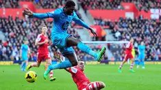 Striker Tottenham Hotspur Emmanuel Adebayor (kiri) menghindari tekel gelandang Southampton Morgan Schneiderlin (kanan) pada pertandingan sepak bola Liga Inggris antara Southampton vs Tottenham Hotspur di Stadion St Mary, Southampton (22/12/13). (AFP/Glyn 