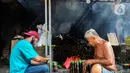 Pekerja memasukan beras ke dalam bambu yang dibungkus daun pisang di industri pembuatan lemang kawasan Senen, Jakarta, Selasa (27/4/2021). Untuk satu batang lemang dijual Rp 15.000 ke penjual makanan yang kemudian dijual kembali Rp 30.000 per batang kepada konsumen.  (Liputan6.com/Johan Tallo)