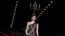 Model mengenakan busana rancangan Moschino dengan hiasan kepala berbentuk tempat lilin dalam Milan Fashion Week Autumn/Winter 2017 di Milan, Italia, (23/2). (AFP Photo / Marco Bertorello)