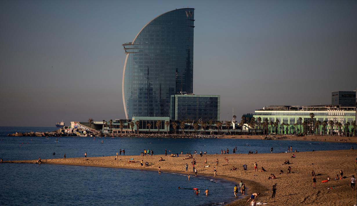Orang-orang menikmati pantai di Barcelona, Spanyol, Rabu, (20/5/2020). Barcelona mengizinkan orang untuk berjalan di pantai Rabu, untuk pertama kalinya sejak dimulainya penutupan virus lebih dari dua bulan lalu. Berjemur dan berenang rekreasi masih tidak diizinkan. (AP Photo/Emilio Morenatti)