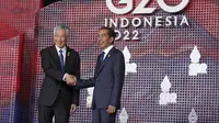 Perdana Menteri Singapura Lee Hsien Loong menyapa Presiden Indonesia Joko Widodo atau Jokowi yang menyambutnya pada hari pertama Konferensi Tingkat Tinggi (KTT) G20 di Nusa Dua, Bali, Selasa (15/11/2022) pagi. Setidaknya total 17 kepala negara G20 akan menghadiri KTT dua hari ini. (Kevin Lamarque/Pool via AP)