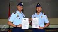 Letkol PNB Anton Palaguna (kiri) dan Lettu PNB Ahmad Finandika menunjukkan sertifikat penghargaan Welldone di Mabes TNI AU, Jakarta, Jumat (21/4). Welldone diberikan atas tingginya profesionalisme kedua penerbang. (Liputan6.com/Helmi Fithriansyah)