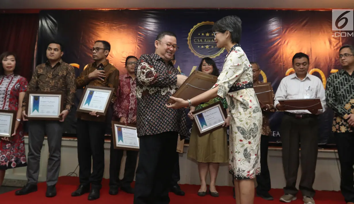 Ketua Umum PROPAMI (kiri) memberi piagam penghargan kepada Head of Protokol and Public Affairs Irnawati W Kahardja yang mewakili PT Surya Citra Media (SCM) Tbk dalam CSA Award 2019, Jakarta, Kamis (18/7/2019). SCM mendapat penghargaan CSA Award 2019 katagori growth stock. (Liputan6.com/Angga Yuniar)