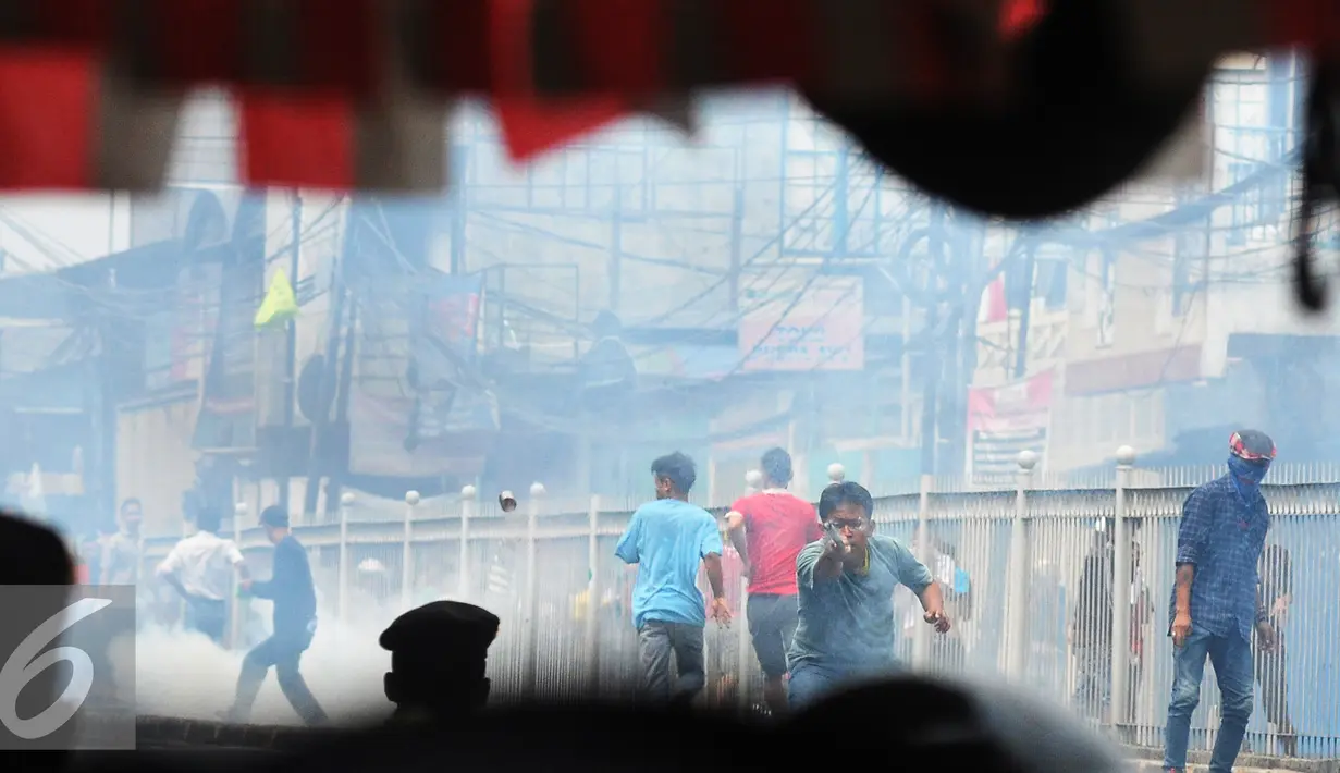 Warga Kampung Pulo menyerang Petugas saat penggusuran Kampung Pulo, Jakarta, Kamis (20/8/2015). Penggusuran pemukiman Kampung Pulo dilakukan oleh 2.200 personel gabungan untuk normalisasi Sungai Ciliwung. (Liputan6.com/Herman Zakharia)