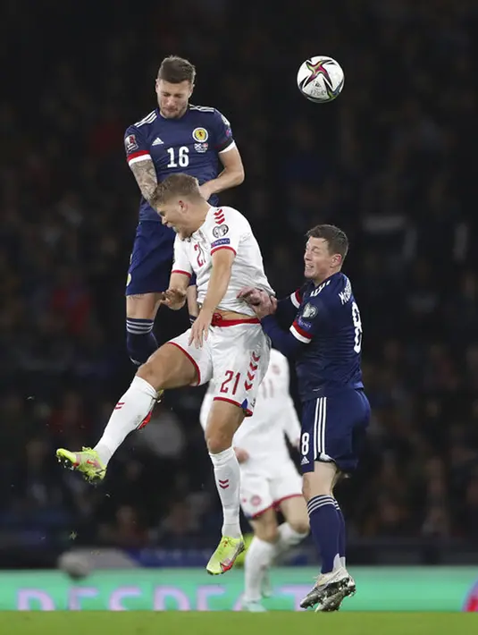 Pemain Skotlandia Liam Cooper (atas) menyundul bola melewati pemain Denmark Andreas Evald Cornelius pada pertandingan sepak bola kualifikasi Grup F Piala Dunia 2022 di Stadion Hampden Park, Glasgow, Skotlandia, 15 November 2021. Skotlandia menaklukkan Denmark 2-0. (AP Photo/Scott Heppell)