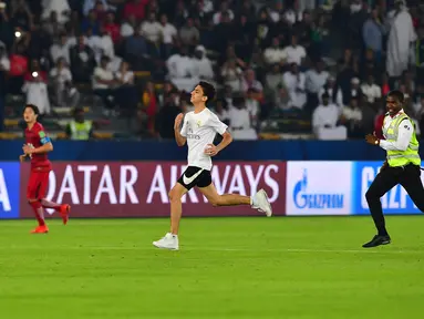 Seorang fans Real Madrid berlari menerebos lapangan selama pertandingan semifinal Piala Dunia Antarklub 2018 antara Real Madrid melawan Kashima Antlers di stadion Zayed Sports City di Abu Dhabi, Uni Emirat Arab (19/12). (AFP Photo/Giuseppe Cacace)