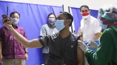 Warga mengabadikan momen saat vaksinasi covid-19 di sentra vaksin Tomang Tol Plaza, Tangerang, Sabtu (24/7/2021). Pemerintah sebelumnya menetapkan target sasaran vaksinasi 181,5 juta atau 70 persen dari total populasi untuk mencapai kekebalan kelompok atau herd immunity. (Liputan6.com/Angga Yuniar)