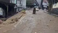 Warga saat melintas di jalan yang terdampak banjir akibat TPT ambruk di Kota Sukabumi (Liputan6.com/Istimewa).