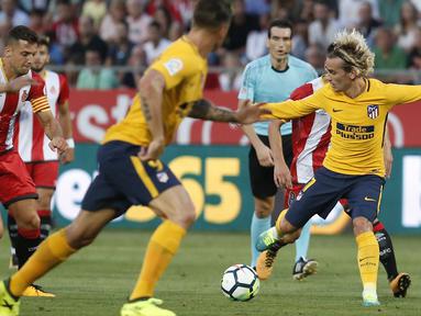 Pemain Atletico Madrid, Antoine Griezmann (kanan) berusaha melewati adangan para pemain Girona FC pada La Liga Spanyol di Montilivi stadium, Girona (19/8/2017). (AFP/Pau Barrena)