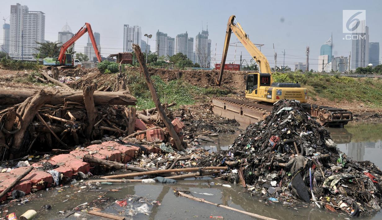 Alat berat terparkir dekat tumpukkan sampah yang muncul di permukaan Kanal Banjir Barat, Jakarta, Selasa (16/7/2019). Kemarau sejak dua bulan terakhir ini menyebabkan sampah-sampah yang mengendap di dasar sungai muncul ke permukaan sehingga menimbulkan bau tak sedap. (merdeka.com/Iqbal S Nugroho)