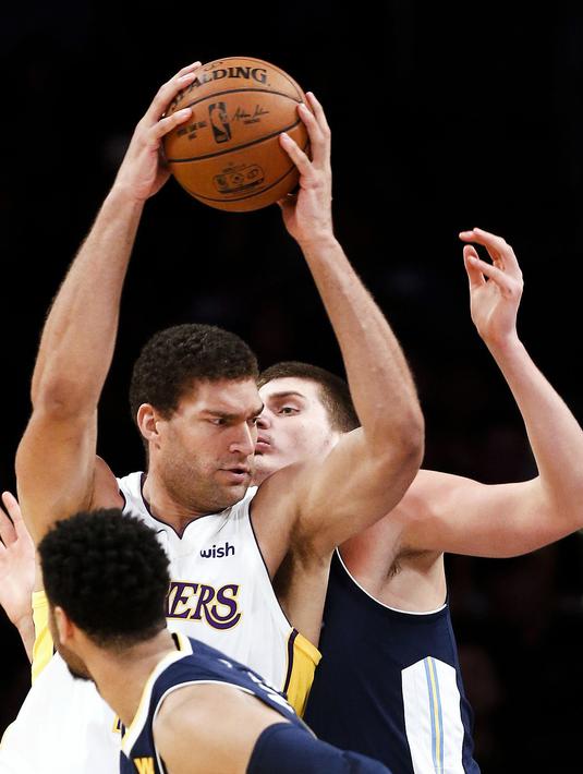 Pemain Los Angeles Lakers, Brook Lopez (tengah) berusaha keluar dari kepungan dua pemain Denver Nuggets pada laga NBA basketball game di Staples Center, Los Angeles, (19/11/2017). Lakers menang 127-109. (AP/Ringo H.W. Chiu)