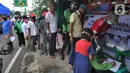 Warga antre mendapatkan nasi bungkus di salah satu warteg kawasan Jalan Tole Iskandar, Depok, Jawa Barat, Rabu (15/4/2020). Sejumlah lembaga sosial berinisiatif memberi bantuan nasi bungkus kepada warga yang terdampak virus corona COVID-19 lewat pemberdayaan warteg. (merdeka.com/Arie Basuki)