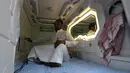 Seorang pria Arab Saudi menggunakan fasilitas kamar kapsul di Makkah, 16 Agustus 2018. Konsep kamar kapsul ini dirasa bakal mempermudah pendatang yang melaksanakan ibadah haji dengan biaya yang terbatas. (AFP/AHMAD AL-RUBAYE)