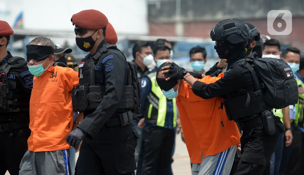 Anggota Densus 88 Antiteror menggiring terduga teroris saat tiba di Bandara Soekarno-Hatta, Tangerang, Banten, Kamis (18/3/2021). Polri memindahkan 22 terduga teroris jaringan kelompok Jamaah Islamiyah (JI) dari Jawa Timur ke Jakarta. (merdeka.com/Imam Buhori)