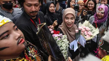 Siti Atiqoh Supriyanti menghadiri acara Hari Disabilitas Internasional yang diselenggarakan oleh Komunitas Disabilitas Tunarungu Indonesia di Bumi Pospera, Cipinang, Jakarta, Minggu (3/12/2023). Atiqoh tampak bahagia disambut oleh para penyandang disabilitas dengan rangkaian bunga. (Liputan6.com/Herman Zakharia)