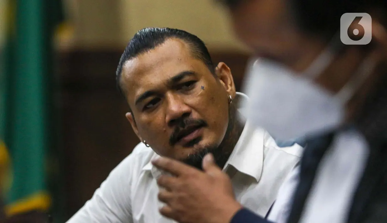 Terdakwa musisi I gede Ari Astina atau Jerinx mengikuti sidang tuntutan di PN Jakarta Pusat, Jakarta, Jumat (18/2/2022). Jerinx dituntut dua tahun penjara dan denda Rp50 juta subsider dua bulan kurungan atas kasus dugaan pengancaman kepada Adam Deni. (Liputan6.com/Herman Zakharia)