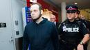 Joshua Boyle dikawal polisi setelah memberi keterangan kepada wartawan di bandara Toronto, Kanada (13/10). Boyle bersama istri dan ketiga anaknya dibebaskan oleh pasukan Pakistan dari tangan Taliban. (Nathan Denette / The Canadian Press via AP)