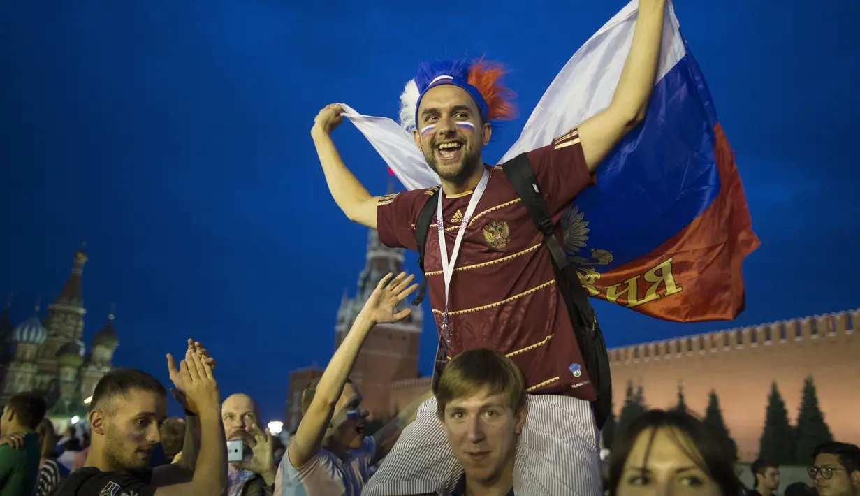 Suporter Rusia berpesta merayakan keberhasilan negaranya mengalahkan Spanyol pada laga 16 besar Piala Dunia di Moskow, Minggu (1/7/2018). Rusia untuk pertama kalinya lolos ke babak perempatfinal. (AFP/Alexander Zemlianichenko)