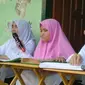 Nanik Nurhayati (Kiri) sedang membaca Al-Qur'an Braille di Pondok Pesantrean KH. Ahmad Dahlan. (Hermawan Arifianto/Liputan6.com )