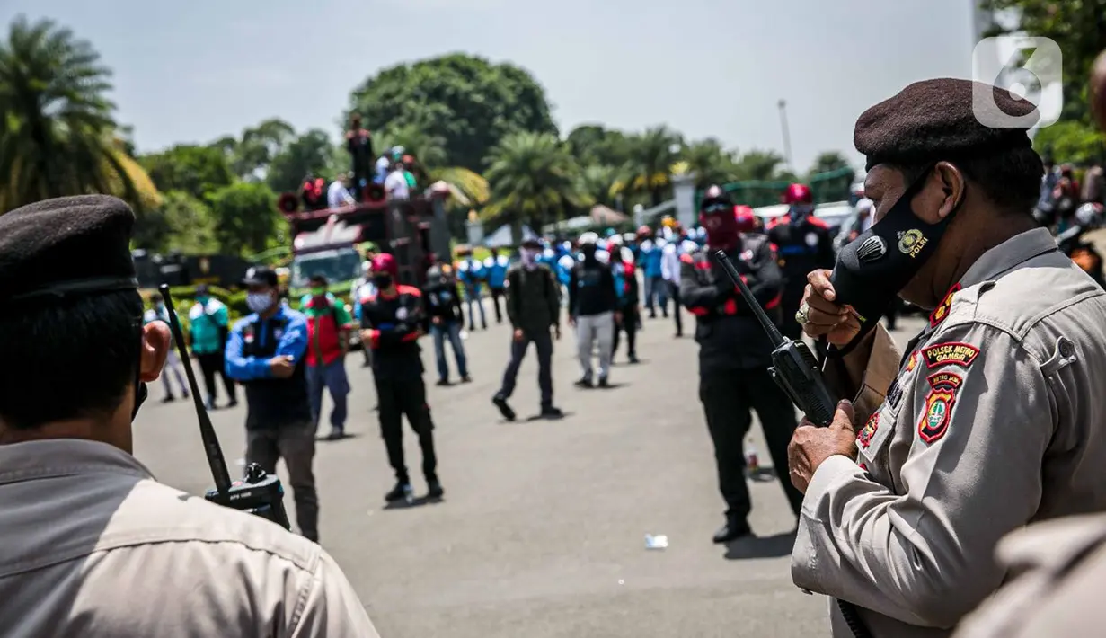 Polisi berjaga saat buruh KSPI berdemonstrasi di kawasan Patung Kuda, Jakarta, Senin (12/4/2021). Buruh menutut pembayaran THR 2021 secara penuh, meminta MK membatalkan Omnibus Law, pemberlakuan UMSK, dan mendesak Kejagung mengusut dugaan korupsi BPJS Ketenagakerjaan. (Liputan6.com/Faizal Fanani)