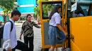 Sejumlah siswa saat menaiki bus gratis di halaman rusun Muara Kapuk, Jakarta, Jumat (22/4/2016). Dua unit Bus gratis ini akan melewati rute Teluk Gong, Bandengan dan Jembatan Lima. (Liputan6.com/Yoppy Renato)