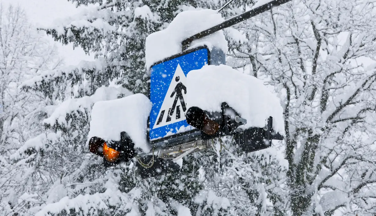 Sebuah rambu jalan tertutup salju di Kocevje, dekat Ljubljana Slovenia, Senin (23/1/2023). Badai salju dengan angin kencang telah menghambat lalu lintas di jalan raya utama di Slovenia pada hari Senin dan menyebabkan beberapa bagian negara tanpa listrik untuk sementara waktu. (AP Photo)