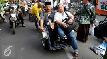 Peserta Muktamar NU menaiki Bentor (Becak Motor) dikawasan Alun - Alun Kota, Jombang, Jawa Timur, Rabu (5/8/2015). Becak motor menjadi Kendaraan pilihan para peserta Muktamar NU untuk keliling Kota Jombang. (Liputan6.com/JohanTallo)