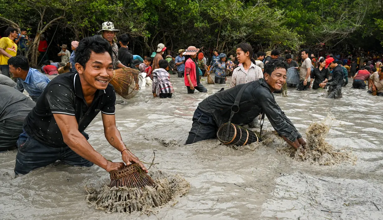 Penduduk desa menangkap ikan selama upacara penangkapan ikan tahunan di komune Choam Krovean di provinsi Tboung Khmum pada 18 Februari 2023. Dengan menggunakan keranjang bambu buatan tangan dan jaring nilon, ratusan orang mengarungi danau berlumpur setinggi paha di Kamboja timur pada hari Sabtu untuk upacara penangkapan ikan tahunan, di mana hanya alat-alat tradisional yang digunakan. (AFP/Tang Chhin Sotthy)