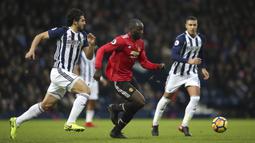 Striker Manchester United (MU), Romelu Lukaku, berusaha melewati bek West Bromwich Albion (WBA), Ahmed Hegazi, pada laga Premier League di Stadion The Hawthorns, Minggu (17/12/2017). MU menang 2-1 atas WBA. (AP/Nick Potts)