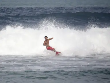 Atlet Timnas Surfing Indonesia, I Made Pajar Ariana, berlatih di Pantai Berawa, Kuta Utara, Selasa (15/9/2026), sebagai bagian dari persiapan menghadapi Asian Games 2026 di Aichi-Nagoya, Jepang. Pajar menjalani latihan untuk beradaptasi dengan berbagai kondisi ombak sebelum bertolak ke Jepang. (Bola.com/Alit Binawan)