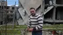 Mohamed Ataya atau yang dikenal sebagai "Abu Maher" menanam tanaman di atap sebuah gedung yang rusak di Ghouta, pinggiran Damaskus, Suriah (3/3). (AFP/Amer Almohibany)