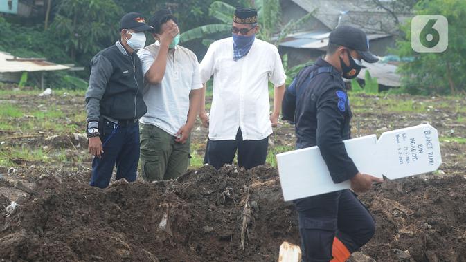 Tangis keluarga jenazah kasus COVID-19 mengunjungi pemakaman di TPU Srengseng Sawah 2, Jakarta, Selasa (9/2/2021). Sudah lebih dari sepekan TPU Srengseng Sawah 2 menerima pemakaman korban COVID-19 dengan jumlah yang dimakamkan sehari maksimal 10 jenazah. (merdeka.com/Arie Basuki)