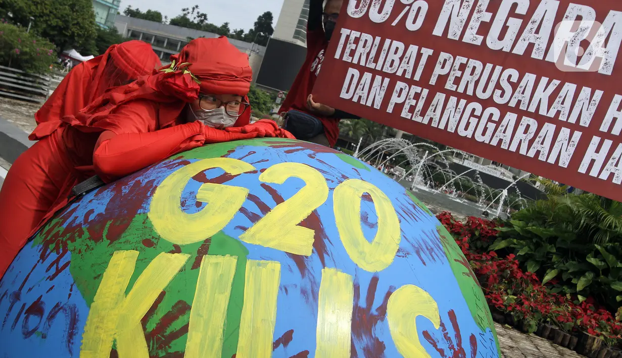 Aktivis lingkungan dari Extinction Rebellion Indonesia melakukan aksi penanganan mitigasi krisis iklim di Bundaran HI, Jakarta, Minggu (13/11/2022). Aktivis menuntut kepedulian negara-negara peserta KTT G20 untuk melakukan transisi energi yang berkelanjutan dan berkeadilan dalam krisis iklim. (merdeka.com/Arie Basuki)