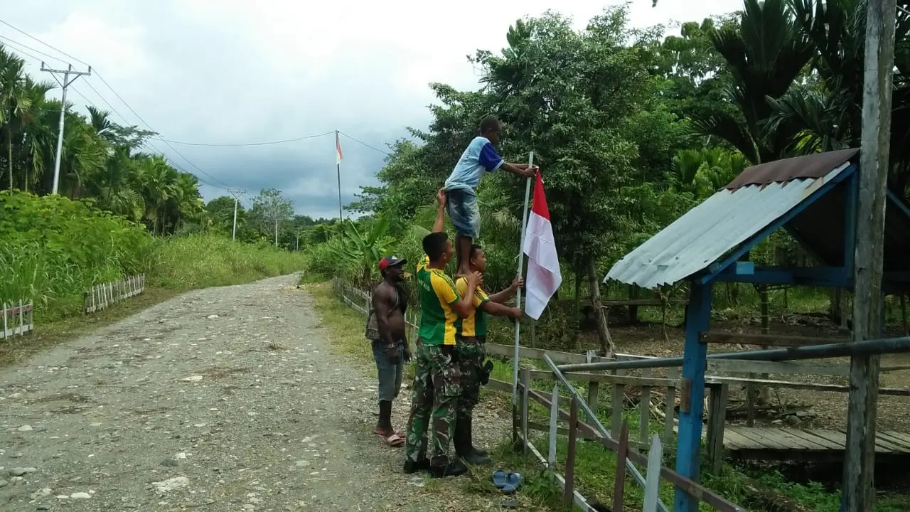 Prajurit TNI mengajak pemuda Yetti mengibarkan Bendera Merah Putih serentak jelang Hari Kemerdekaan. (dok TNI)