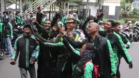 Sejumlah pengemudi ojek online berswafoto dengan polisi saat melakukan aksi di seberang Istana Merdeka, Jakarta, Selasa (27/3). (Liputan6.com/Arya Manggala)