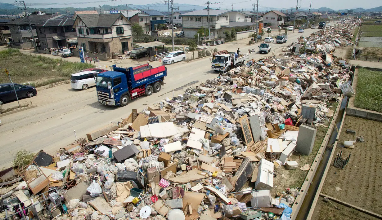 Tumpukan barang rumah tangga yang rusak di sepanjang jalan daerah Mabicho, Kurashiki, Prefektur Okayama, Jumat (13/7). Hujan lebat memicu banjir yang menewaskan 204 orang. (Jiji Press/AFP)