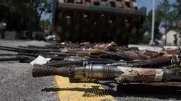 Sejumlah senjata api hasil sitaan dihancurkan di Rio de Janeiro, Brasil, Rabu (20/12). Senjata api sitaan ini dihancurkan dengan cara dilindas mesin pelindas aspal. (AP Photo/Leo Correa)
