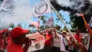 Para pengunjuk rasa menyalakan suar saat aksi demonstrasi pada hari kelima demonstrasi nasional yang diselenggarakan sejak awal tahun, menentang perombakan pensiun yang sangat tidak populer, di Saint-Denis-de-la-Reunion, di pulau seberang lautan Prancis, La Reunion, Kamis (16/2/2023). (Richard BOUHET/AFP)