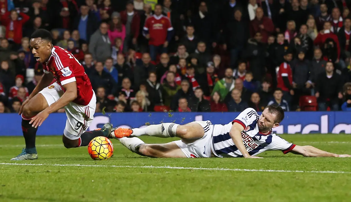 Penyerang MU, Anthony Martial dijatuhkan pemain WBA, Gareth McAuley pada laga Liga Premier Inggris di Stadion Old Trafford, Inggris, Sabtu (7/11/2015). (Reuters/Andrew Yates)